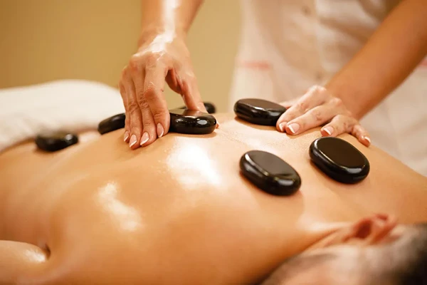 Therapeutic hot stone massage on pressure points to melt away body stiffness.
