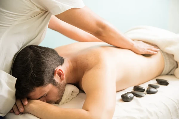 Therapeutic hot stone male massage in Shaheen Bagh to relieve muscle tension and improve blood flow.