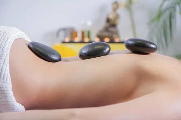 Heated stones applied to the back to stimulate blood flow and deep muscle relaxation.