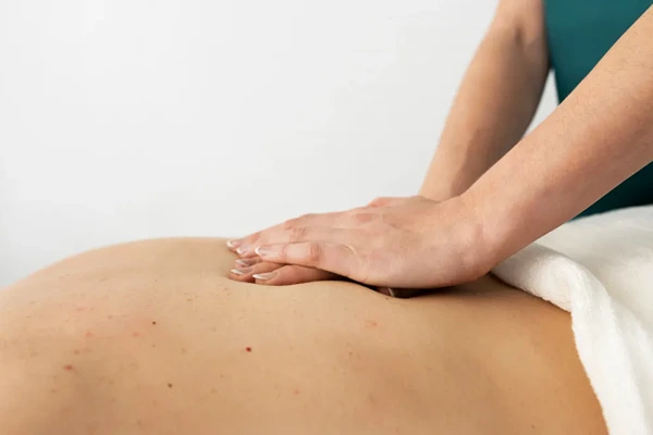 Professional male massage therapist applying natural oil during customized full body massage therapy for men