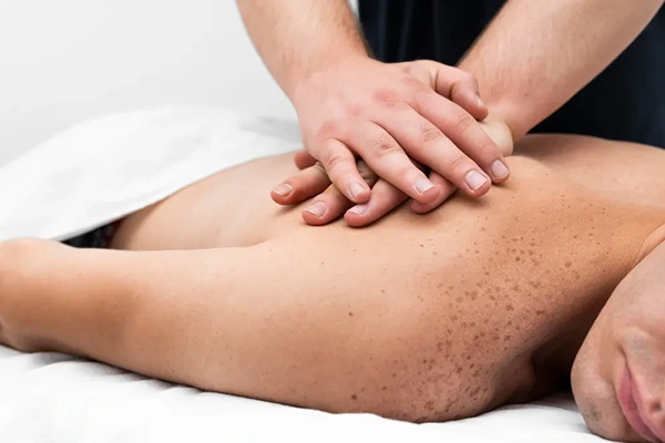 Professional Swedish massage therapist using light pressure for full body muscle softening.